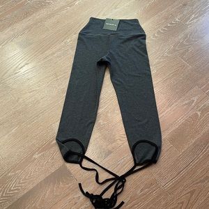 Grey leggings with black laces at bottom. Brand new.
